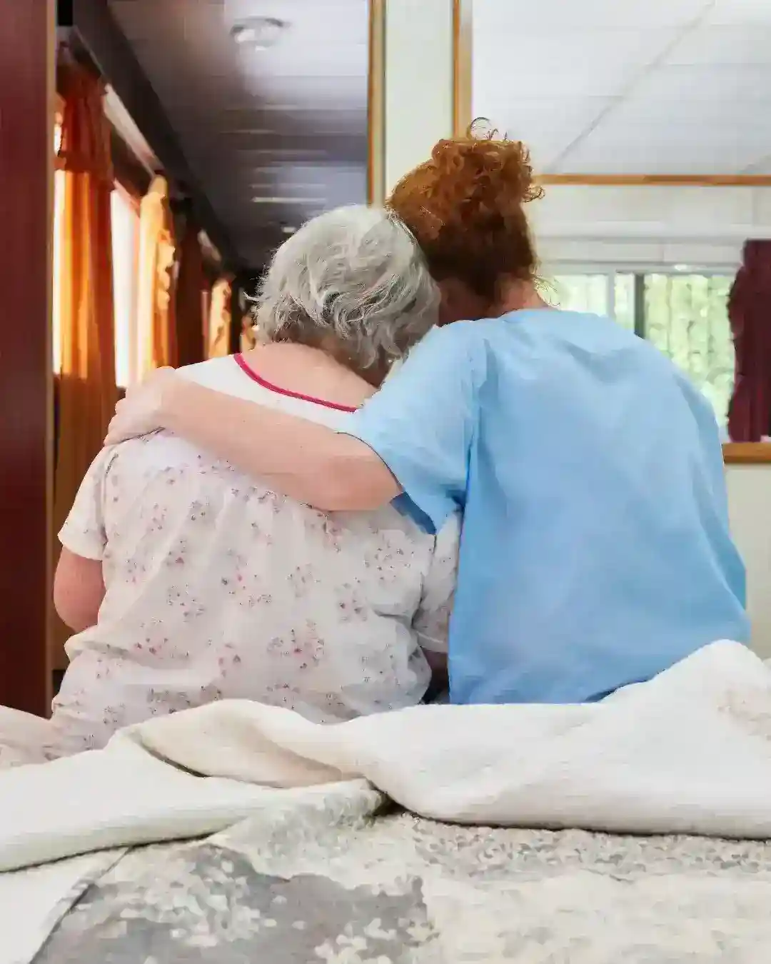 Hospice nurse comforting an elderly patient with compassionate care
